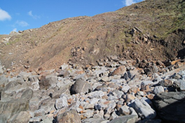 Deposition of weathered rock from a cliff occurs where the rocks have settled at the base of the cliff.